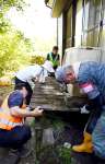 冠水して傾いたテラスを持ち上げるボランティア＝２８日、南さつま市加世田内山田