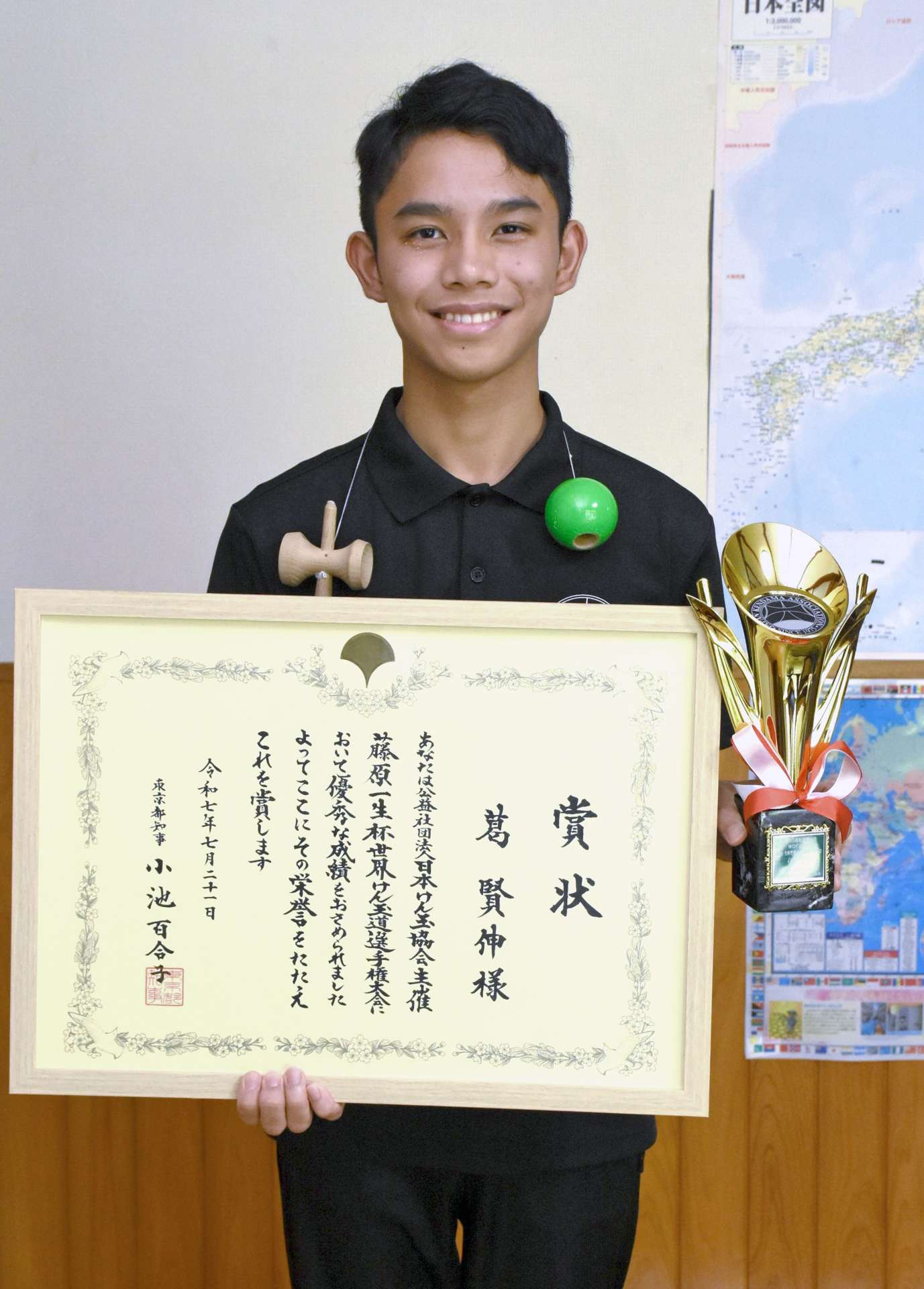 賞状とトロフィーを手に喜ぶ〓賢伸さん＝出水市野田