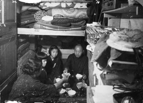 防空壕の中で養父母や友人と食事をする塩田律子さん（右から２人目）＝１９４５年、鹿児島市加治屋町（塩田さん提供）