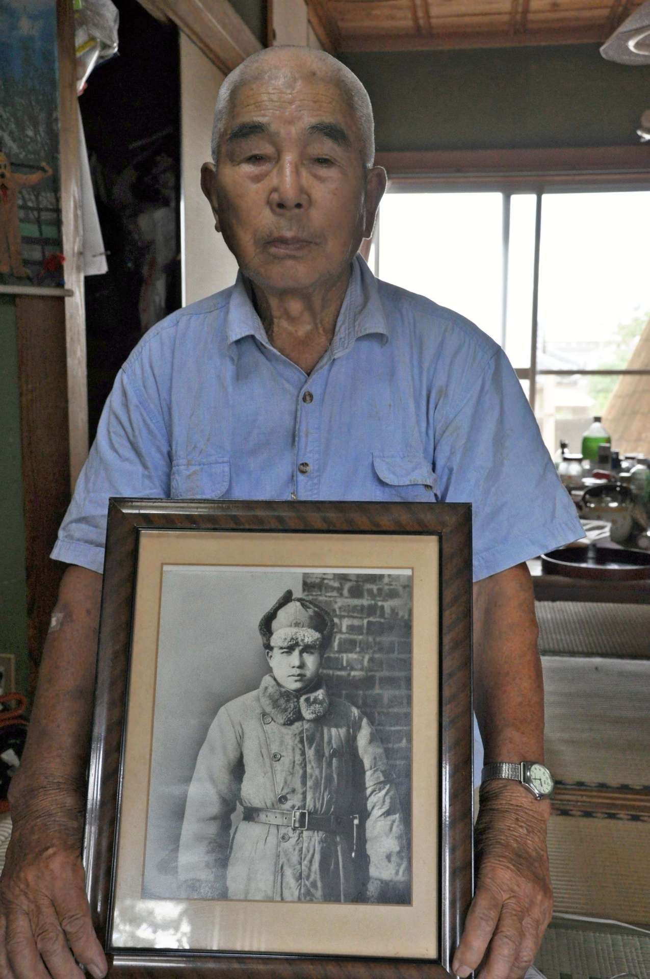 満州の牡丹江で撮影した自身の写真を手にする＝曽於市末吉町二之方