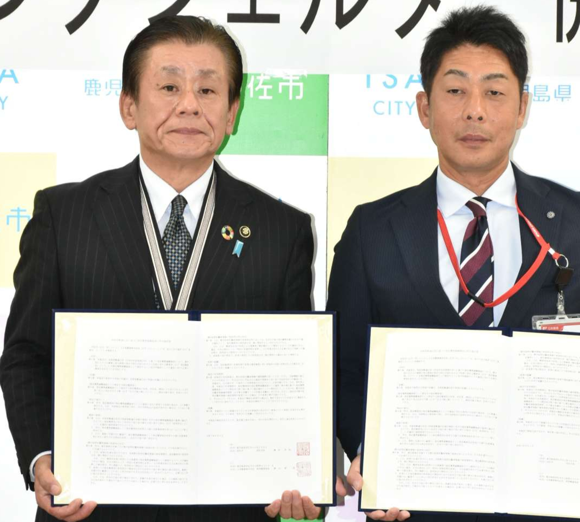 協定書に調印する橋本欣也市長（左）と針持郵便局の隈元啓一郎局長＝伊佐市役所