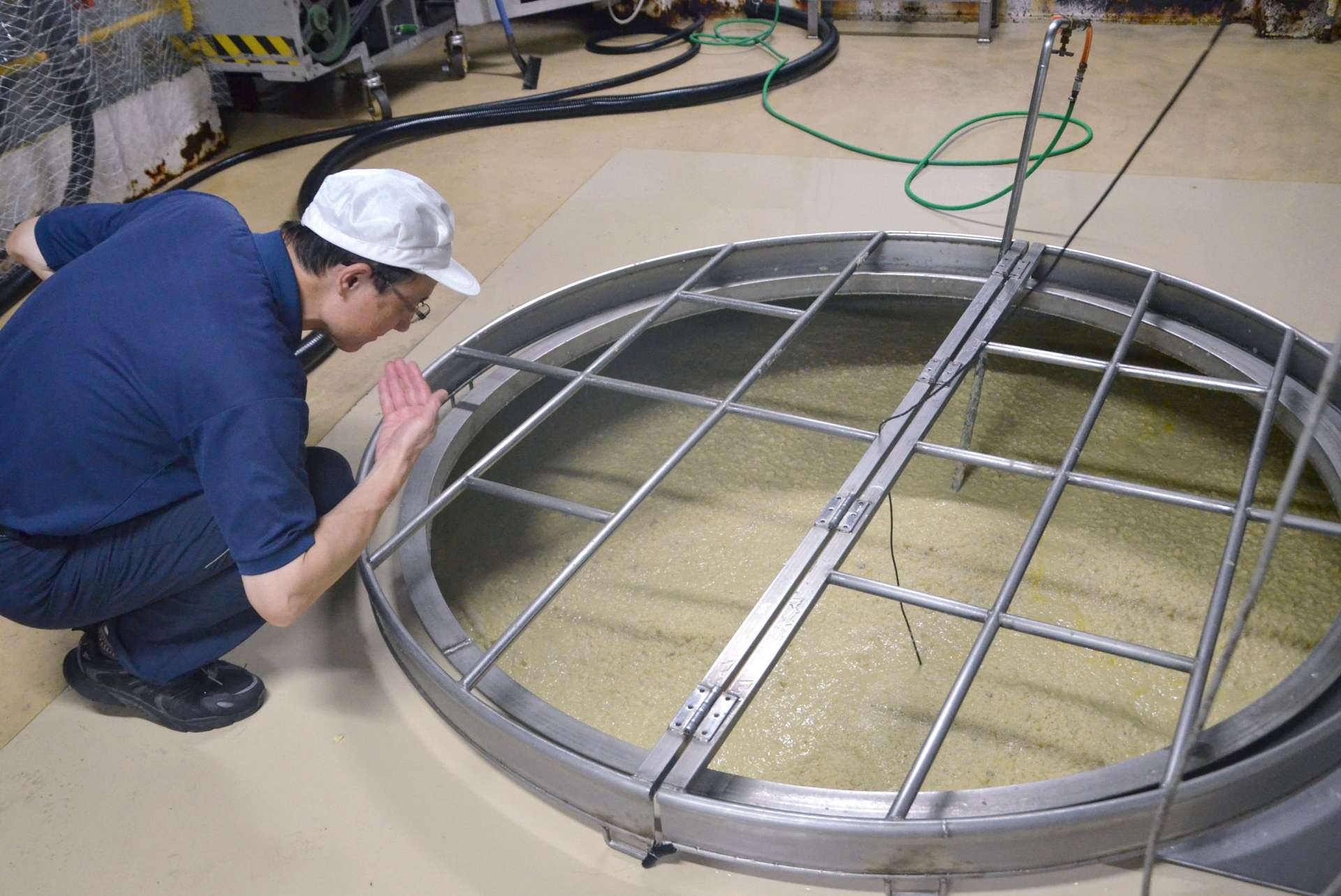 独自の芋こうじを使った「もろみ」の香りを確かめる国分酒造の笹山護社長＝霧島市