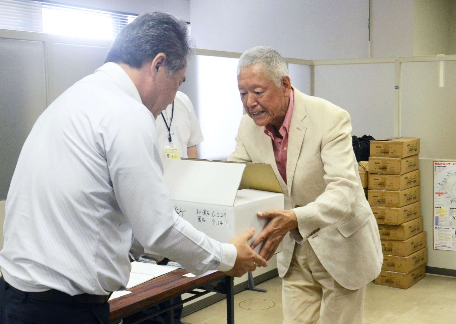 桜島と沖合にある新島を結ぶ行政連絡船存続を求める署名を提出する佐々木直行さん＝鹿児島市役所