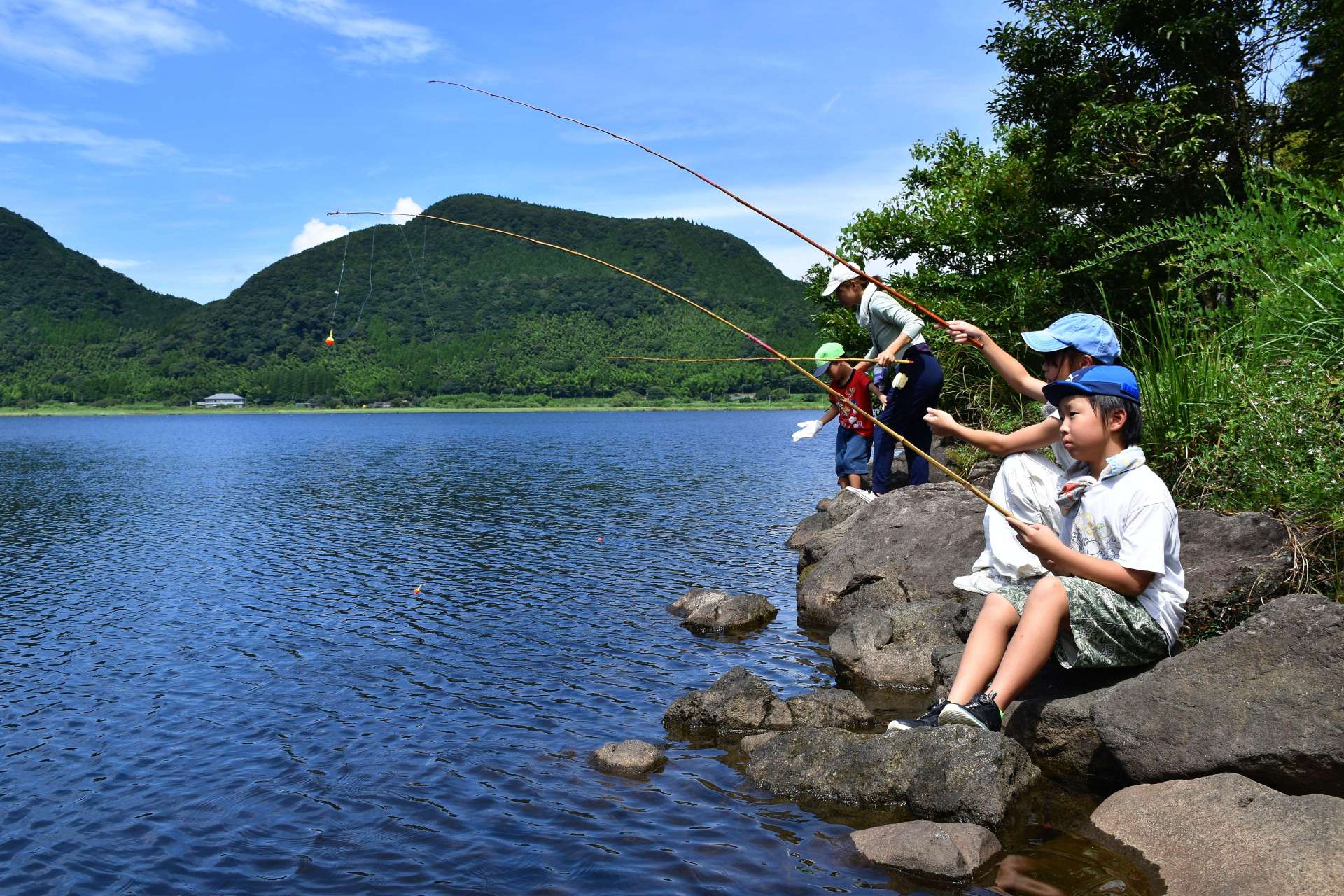 外来魚がかかるのを待つ子ども＝薩摩川内市の藺牟田池