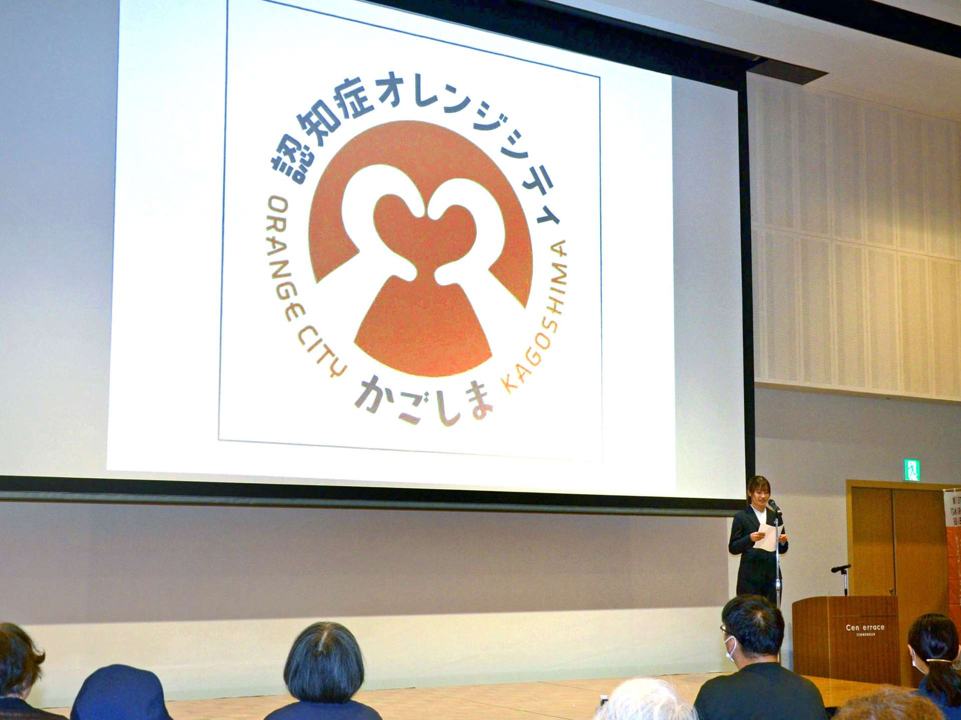 「認知症オレンジシティかごしま」のロゴマークについて語る鹿児島県立短大１年の藤元泉帆さん＝３日、鹿児島市のセンテラス天文館