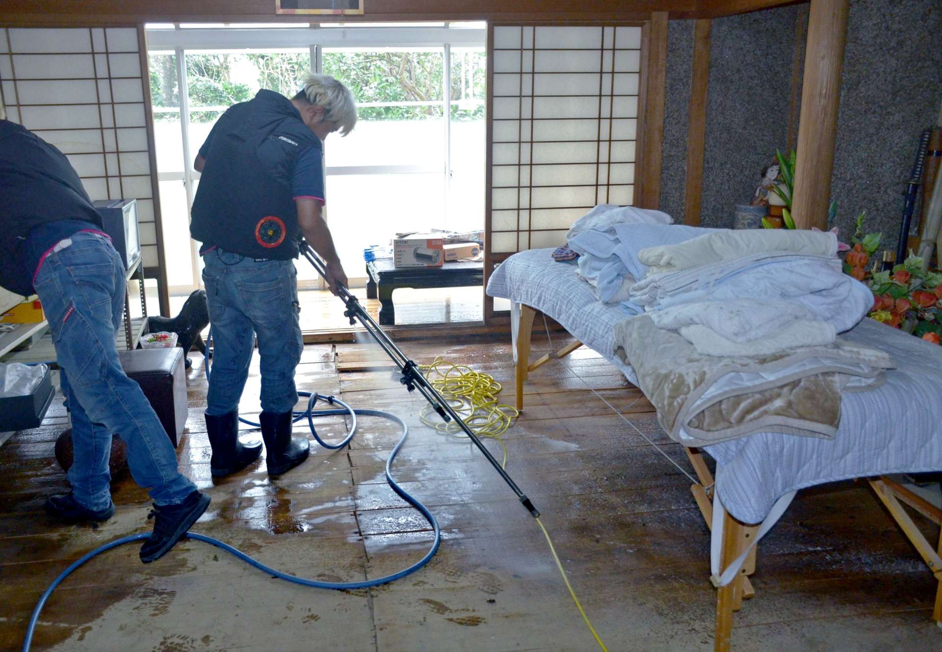 床上浸水した家屋を消毒する作業員＝３日、霧島市隼人