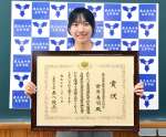 文部科学大臣賞の賞状を手に笑顔を見せる前田美羽さん＝鹿児島市の鹿児島中央高校