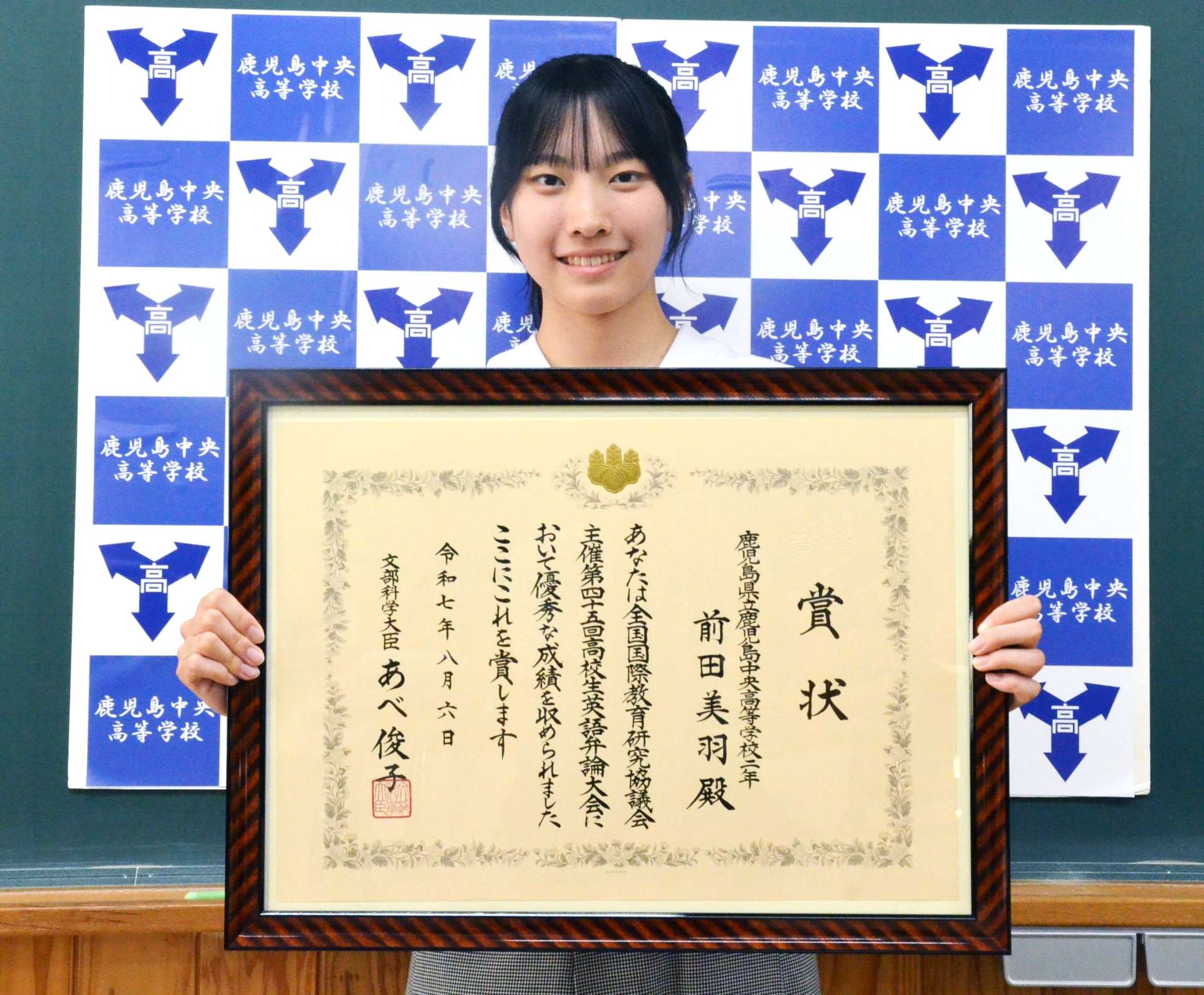 文部科学大臣賞の賞状を手に笑顔を見せる前田美羽さん＝鹿児島市の鹿児島中央高校
