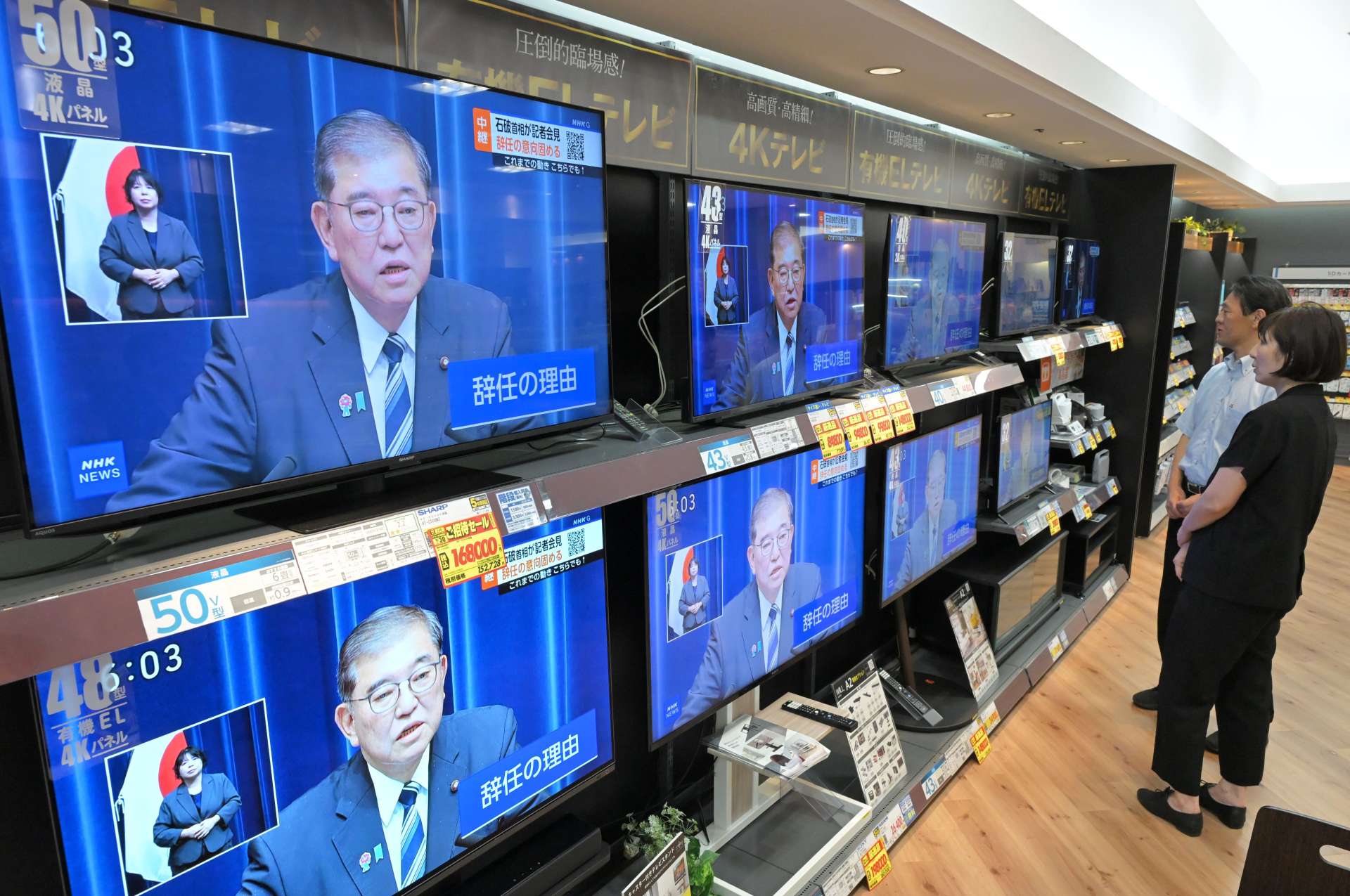 退陣する意向を表明した石破茂首相の記者会見を視聴する市民ら＝７日午後６時すぎ、エディオン鹿児島山形屋店