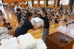 婦人会から贈られた雑巾を受け取る児童＝鹿児島市の谷山小学校