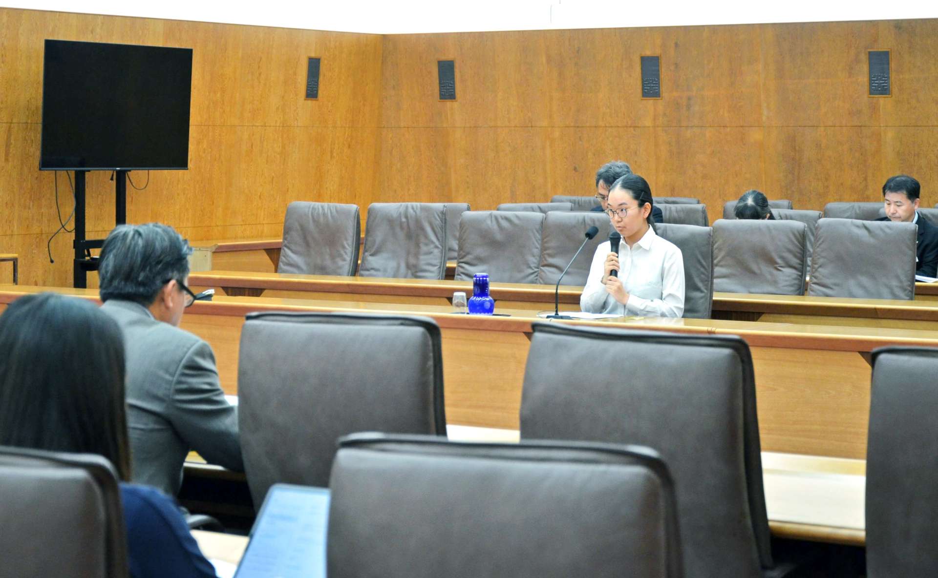 参考人として意見を述べる井上美帆さん＝８日、県議会