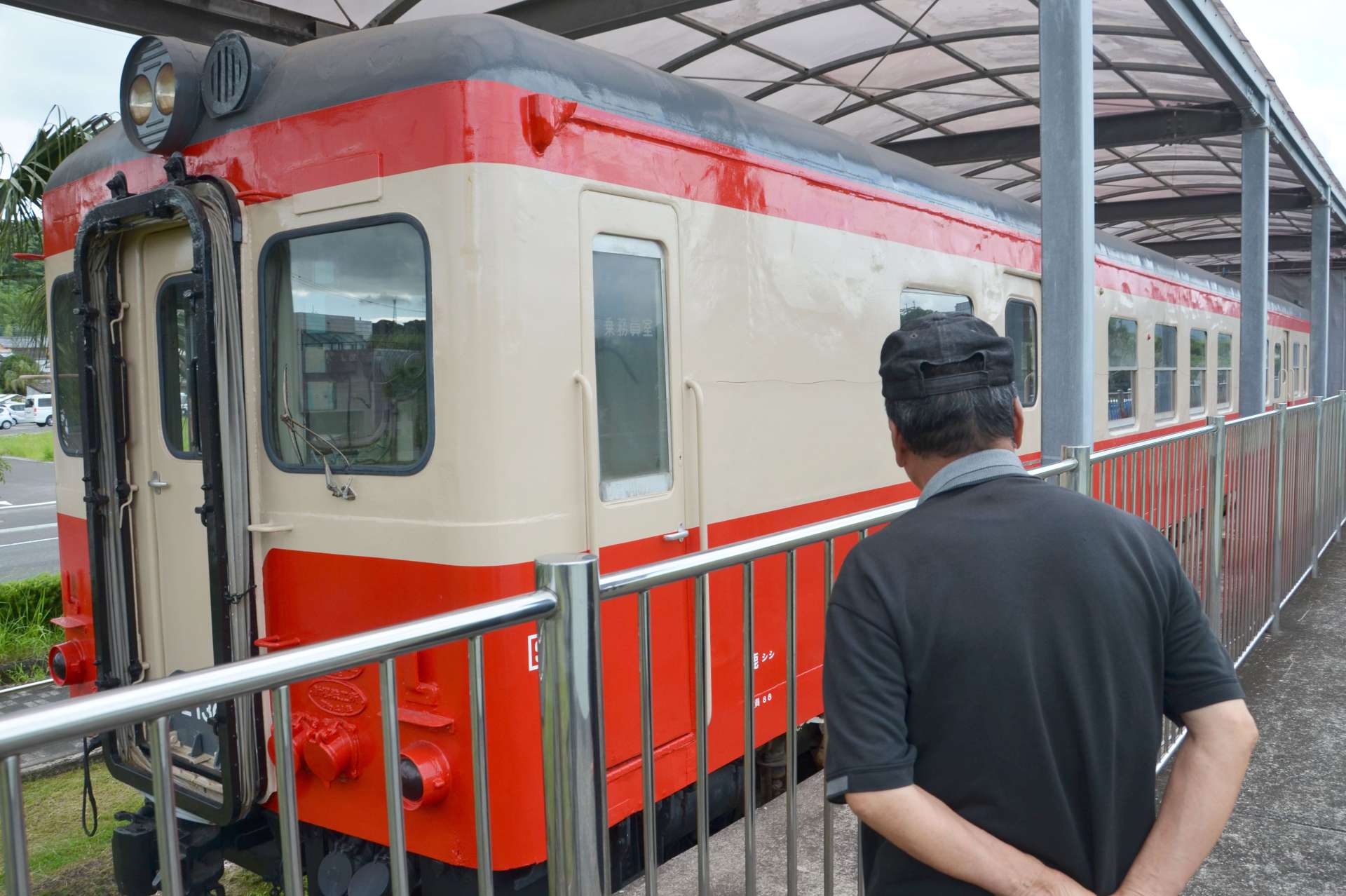 かつて整備した「キハ５２」を眺める伊地知孝さん＝７月、志布志市の志布志鉄道記念公園
