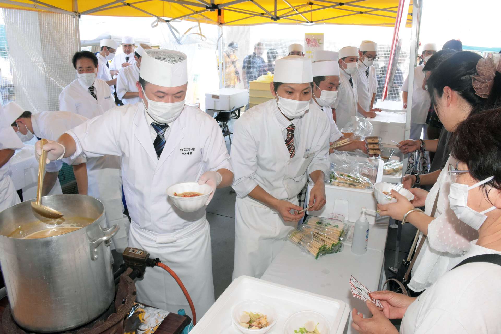 地元産の伊勢エビを使ったみそ汁を提供する料理人ら＝指宿市の指宿港