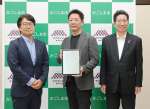 鹿児島市と立地協定を結んだコムテックの伊倉宏英社長（中央）＝４日、同市役所