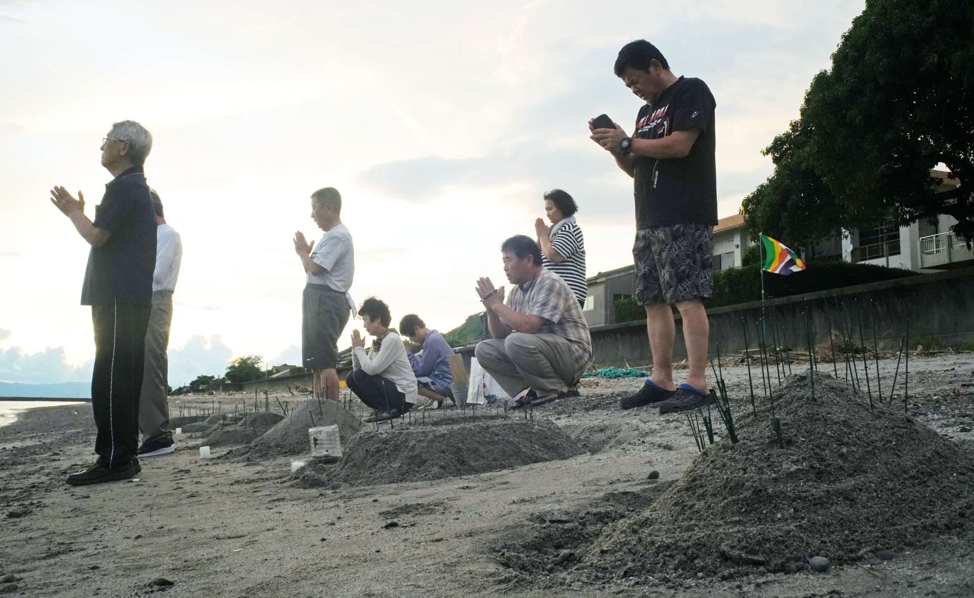砂浜で海難事故や戦争で亡くなった人を悼む柊原地区の住民８月２７日、午後６時４０分ごろ＝垂水市柊原