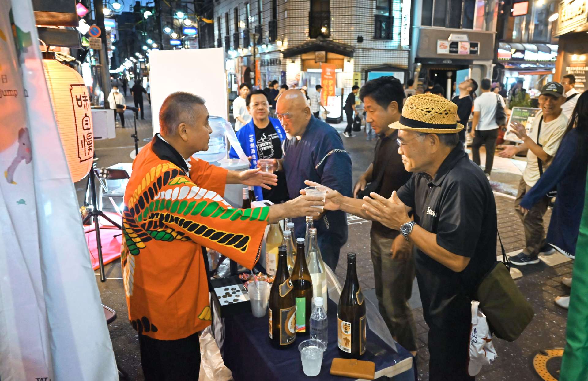 被災地の復興支援にと焼酎やビールのコップを傾ける来場者＝鹿児島市千日町