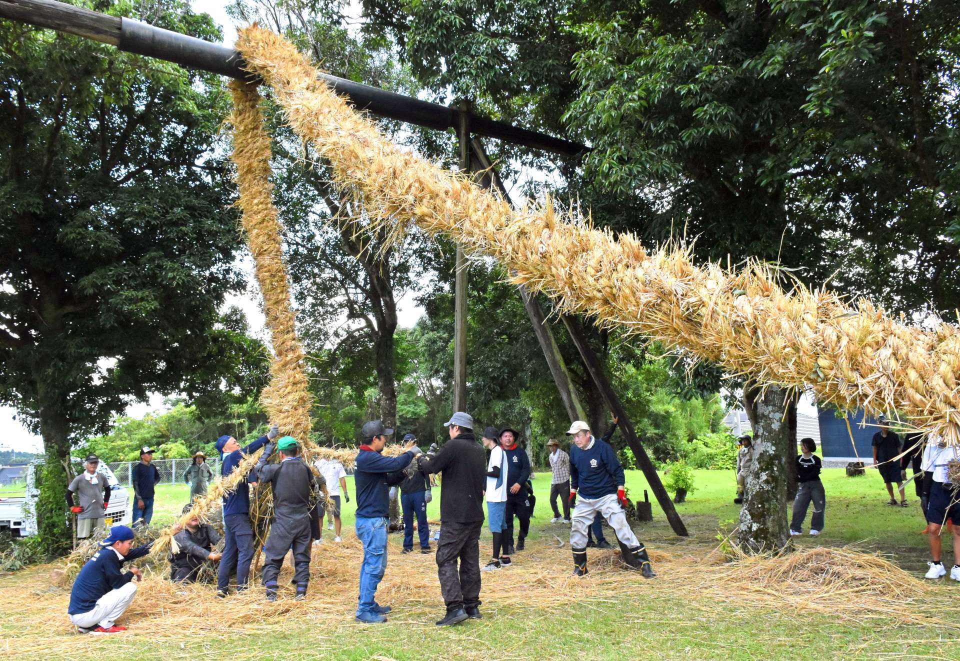 やぐらに綱をかけて編む住民ら＝鹿屋市笠之原町の笠之原公園