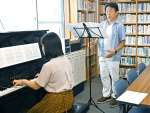 帰郷公演を前に音合わせをする池田敏也さん（奥）＝８日、鹿児島市加治屋町