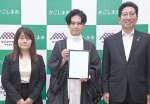 鹿児島市と立地協定を結んだアルサーガパートナーズの小俣泰明社長（中央）＝鹿児島市役所