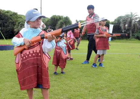 水鉄砲を撃ち合う子どもたち＝１３日午前、大崎町中央運動公園