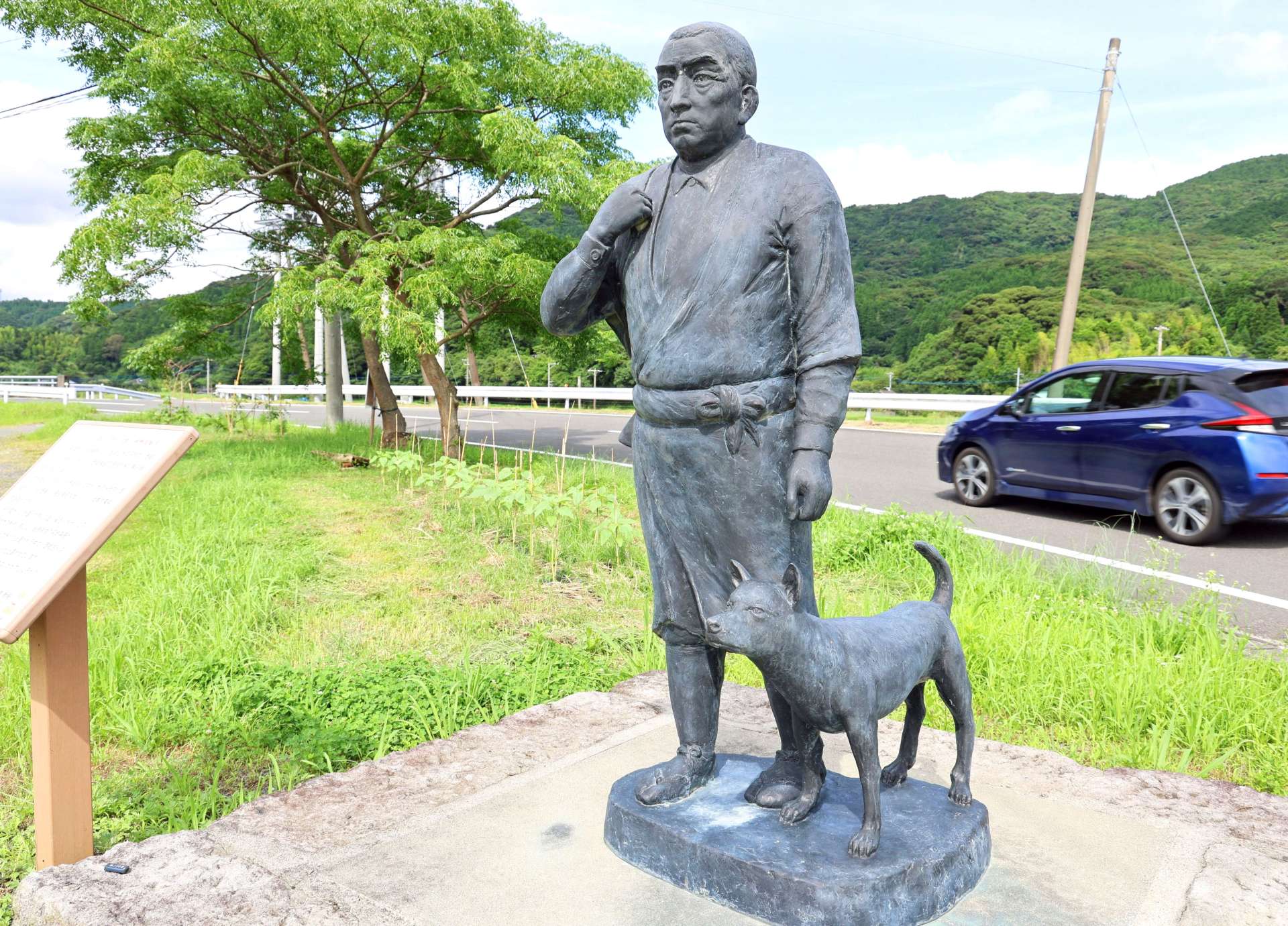 西郷を実物大で再現した銅像。鉄砲を持って狩りに向かう姿のわきに「ツン」がいる＝薩摩川内市湯田町