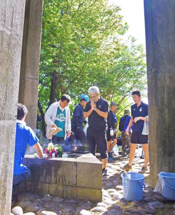 〈関連〉「くれないの塔」に手を合わせる参加者＝奄美市名瀬のらんかん山