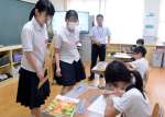 三角定規を使った平行線の引き方を教える志布志高校の生徒＝志布志市の森山小