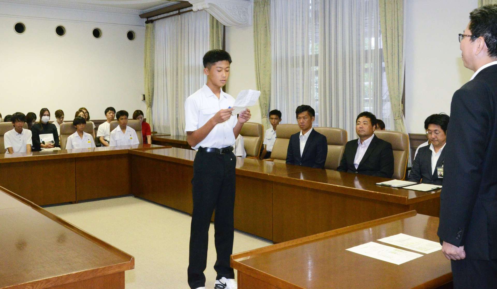 生徒を代表してあいさつする紫原中学校３年の大迫康暉さん＝鹿児島市役所