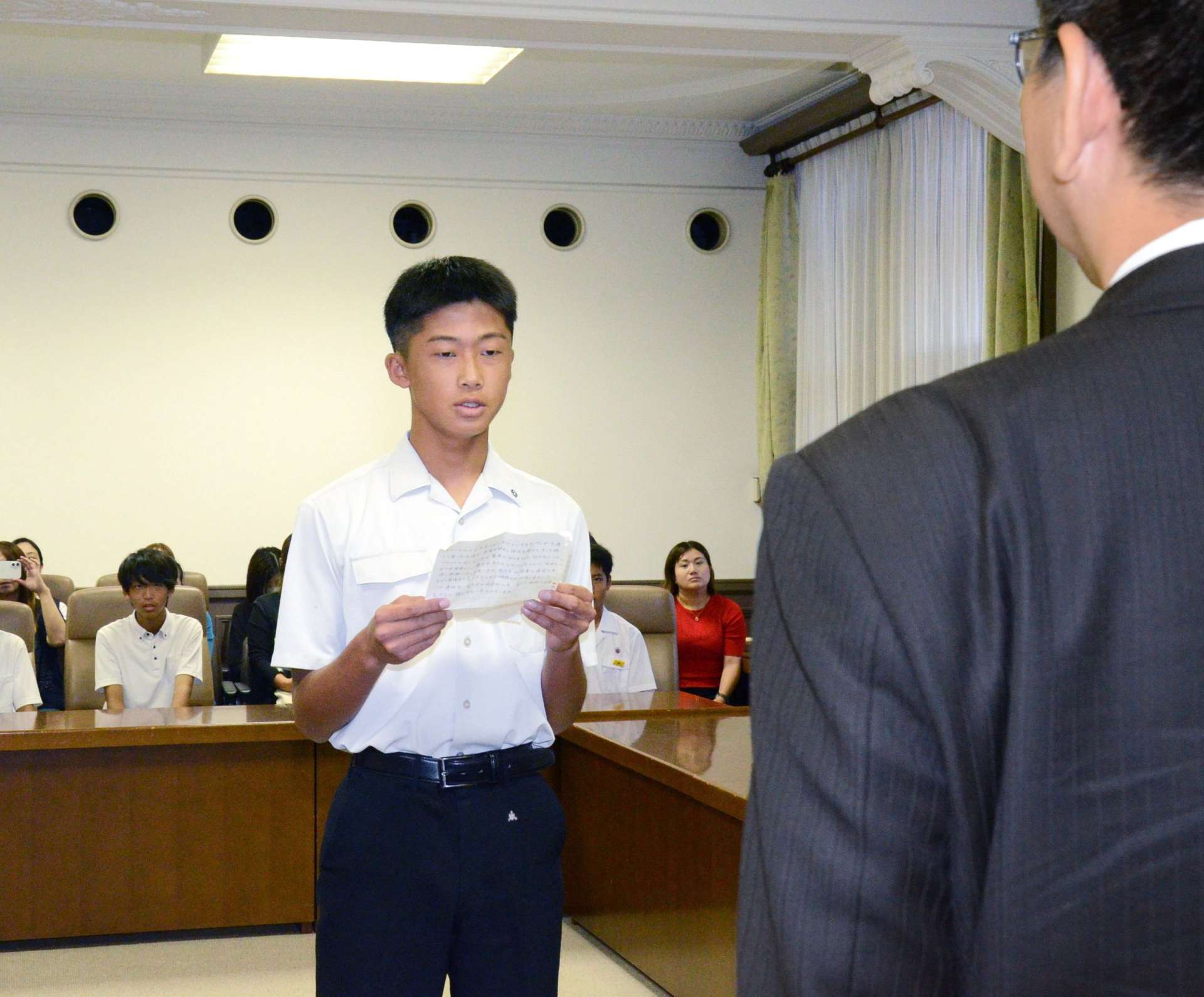 生徒を代表してあいさつする紫原中学校３年の大迫康暉さん＝鹿児島市役所