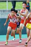 男子４００メートルリレーを制した鹿中央（左）。３走吉留（右）からアンカー井上へバトンが渡る＝白波スタジアム
