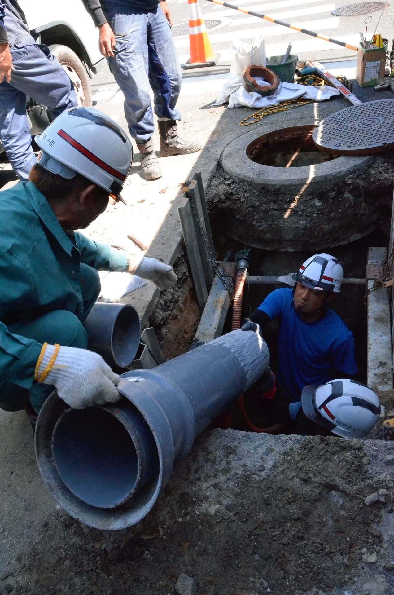 〈資料写真〉陶製の下水管を塩化ビニール製に交換する業者＝２０２４年４月２５日、鹿児島市薬師２丁目