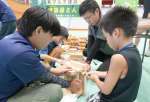 地元企業の仕事を体験する小学生＝鹿屋市串良の串良平和アリーナ