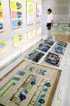 ボンネットバスの写真や手描きの塗装図面などが並ぶ展示会場＝１７日、鹿児島市の天文館図書館
