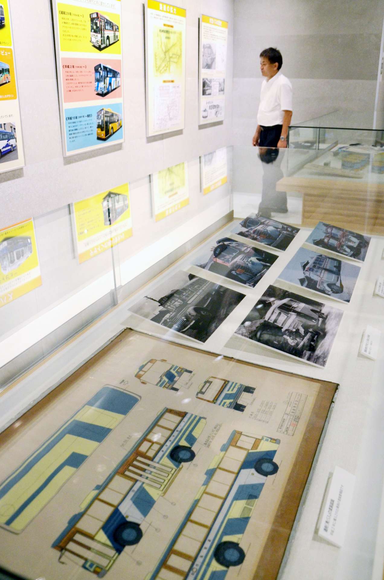 ボンネットバスの写真や手描きの塗装図面などが並ぶ展示会場＝１７日、鹿児島市の天文館図書館