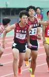男子１６００メートルリレーを制した鹿児島。２走の藤井（右）から３走堀之内にバトンをつなぐ＝白波スタジアム