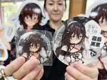 霧島の温泉むすめ「霧島黒恵」の缶バッジ（左）とステッカー＝霧島市霧島田口