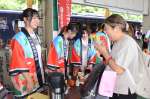 山川高校の生徒からおもてなしを受けるおれんじ食堂の乗客＝２０日、指宿市のＪＲ山川駅