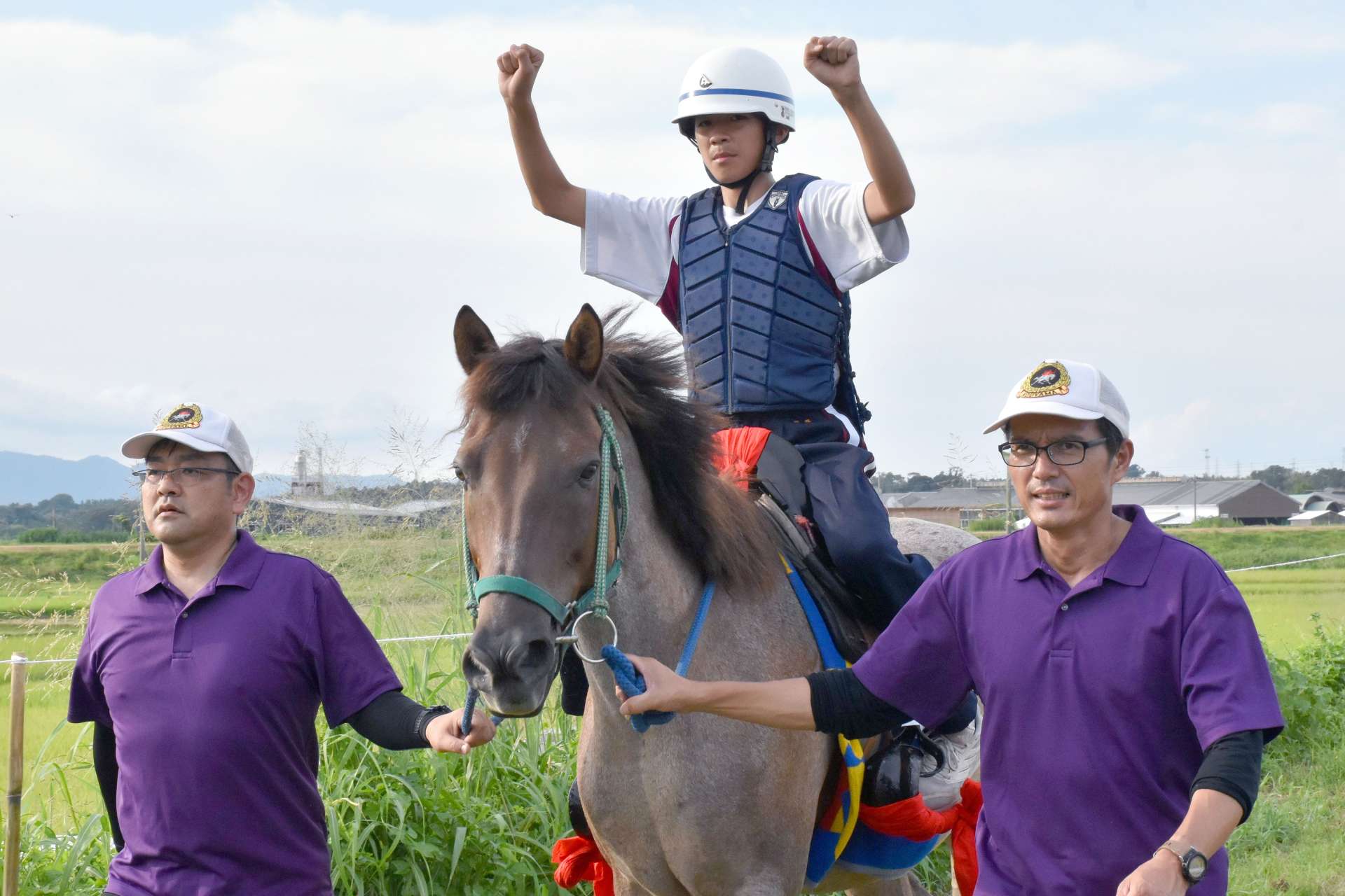 両腕を上げたまま馬に乗る練習をする近藤颯海真さん（中央）＝肝付町前田