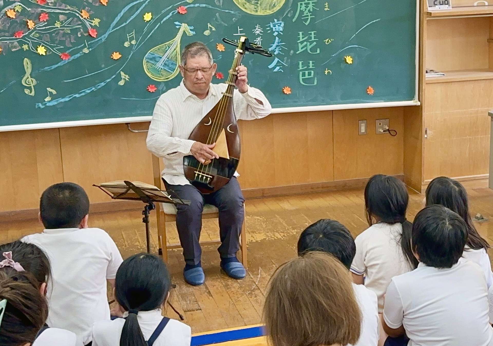 薩摩琵琶を弾奏する上川路直光さん＝南九州市川辺の大丸小学校