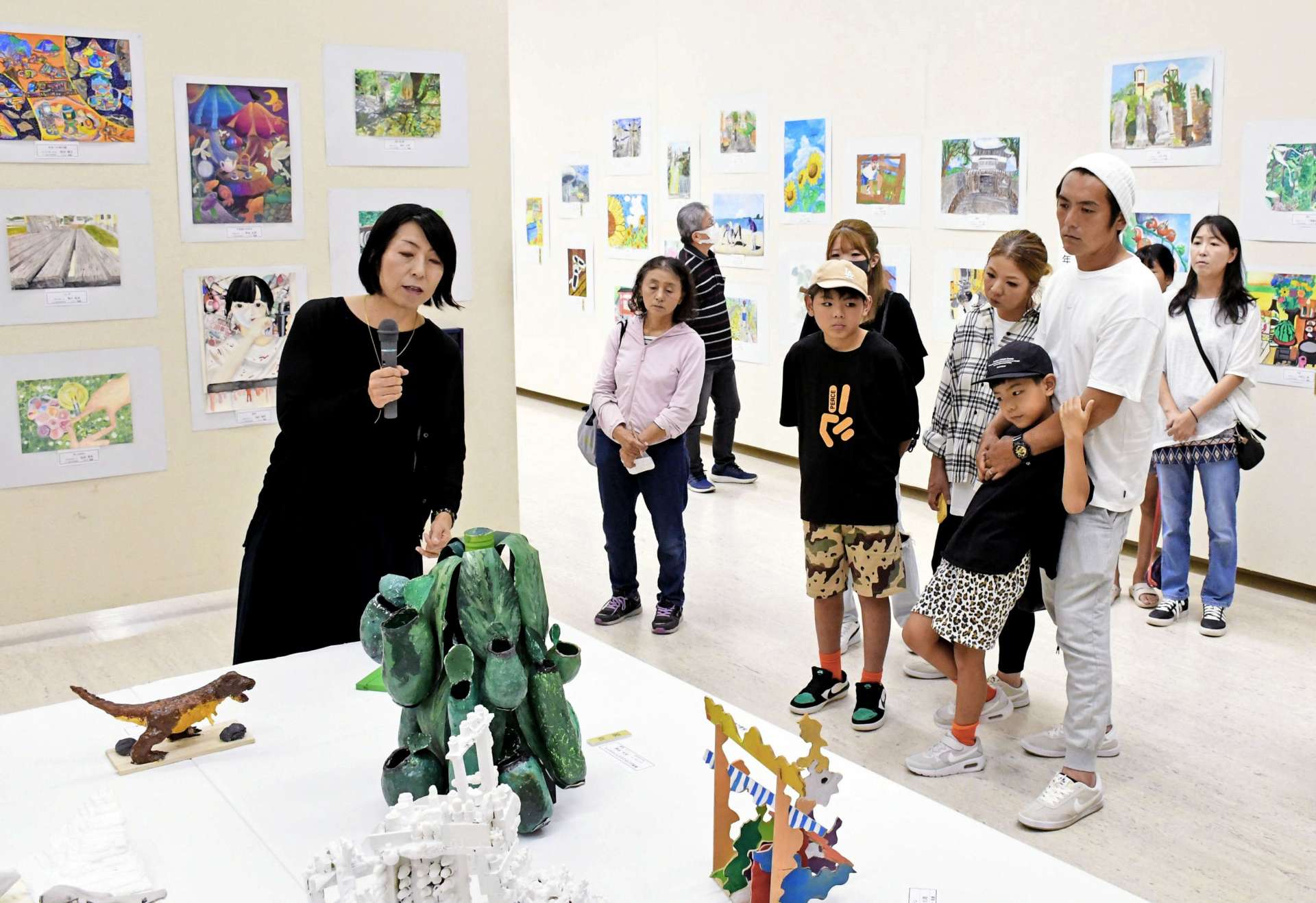中野裕子さん（左）の解説に耳を傾ける参加者＝２１日、鹿児島市立美術館