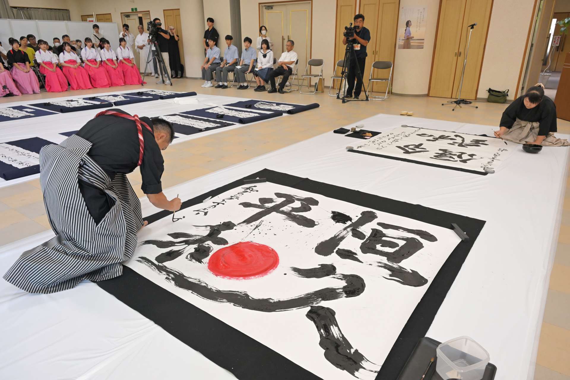 力強い筆運びで揮毫する書家＝２１日、鹿児島市の県護国神社