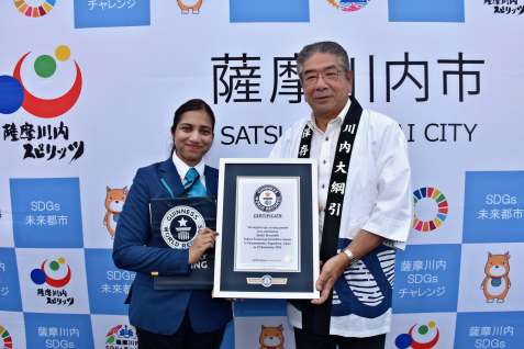 ギネス世界記録の認定証を手にする川内大綱引保存会の橋口知章会長（右）＝２２日、薩摩川内市大小路町