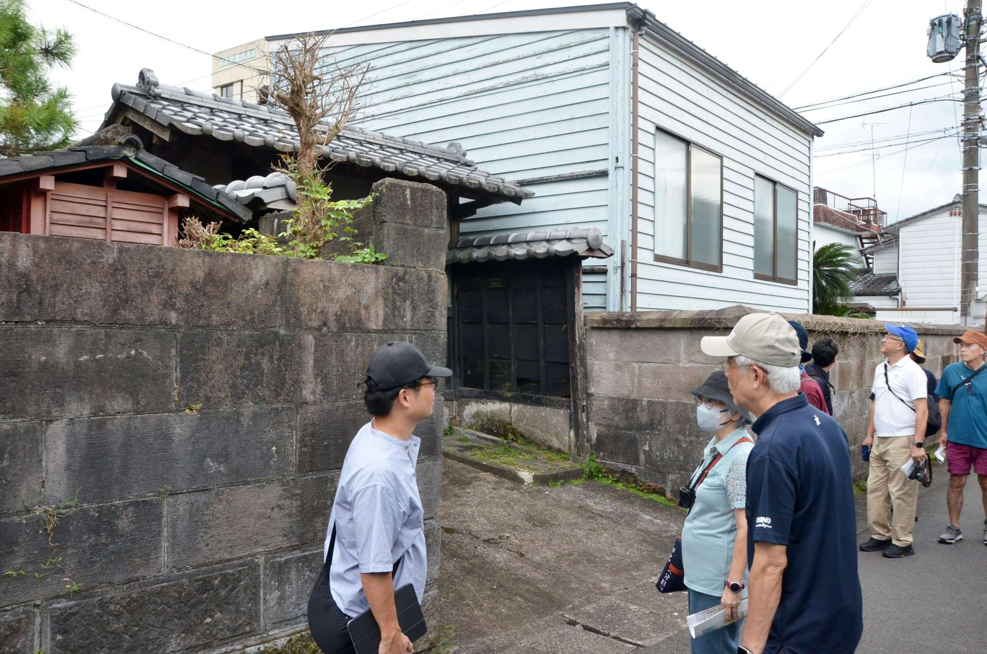 石垣の残る都城市中心市街地の街歩きを楽しむ参加者＝同市蔵原町