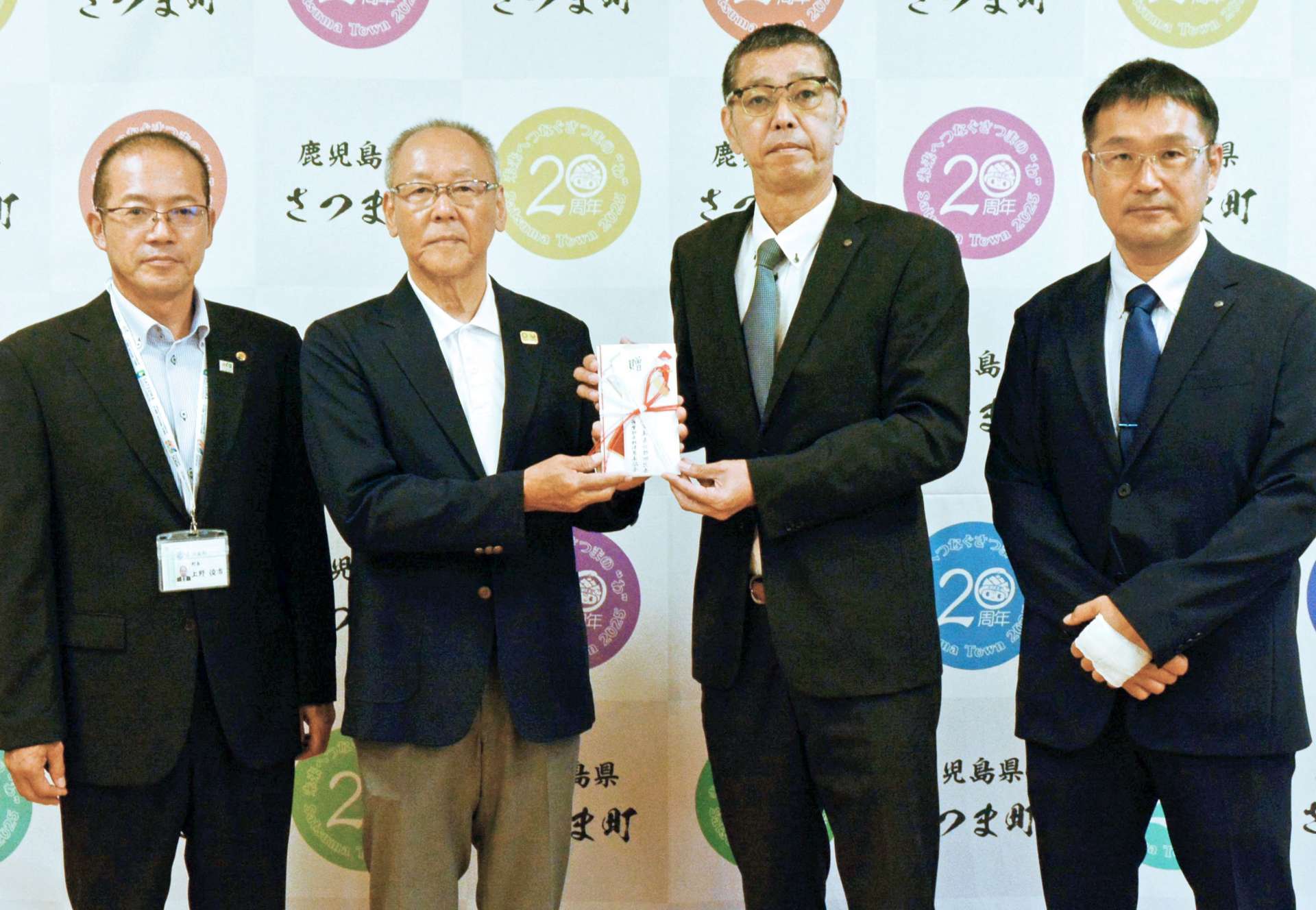 寄付する九州郵便局長協会薩摩部会の米森聖司部会長（右から２人目）＝さつま町役場