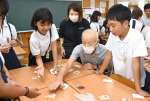 かるた取りを楽しむ高齢者と児童＝出水市の東出水小学校