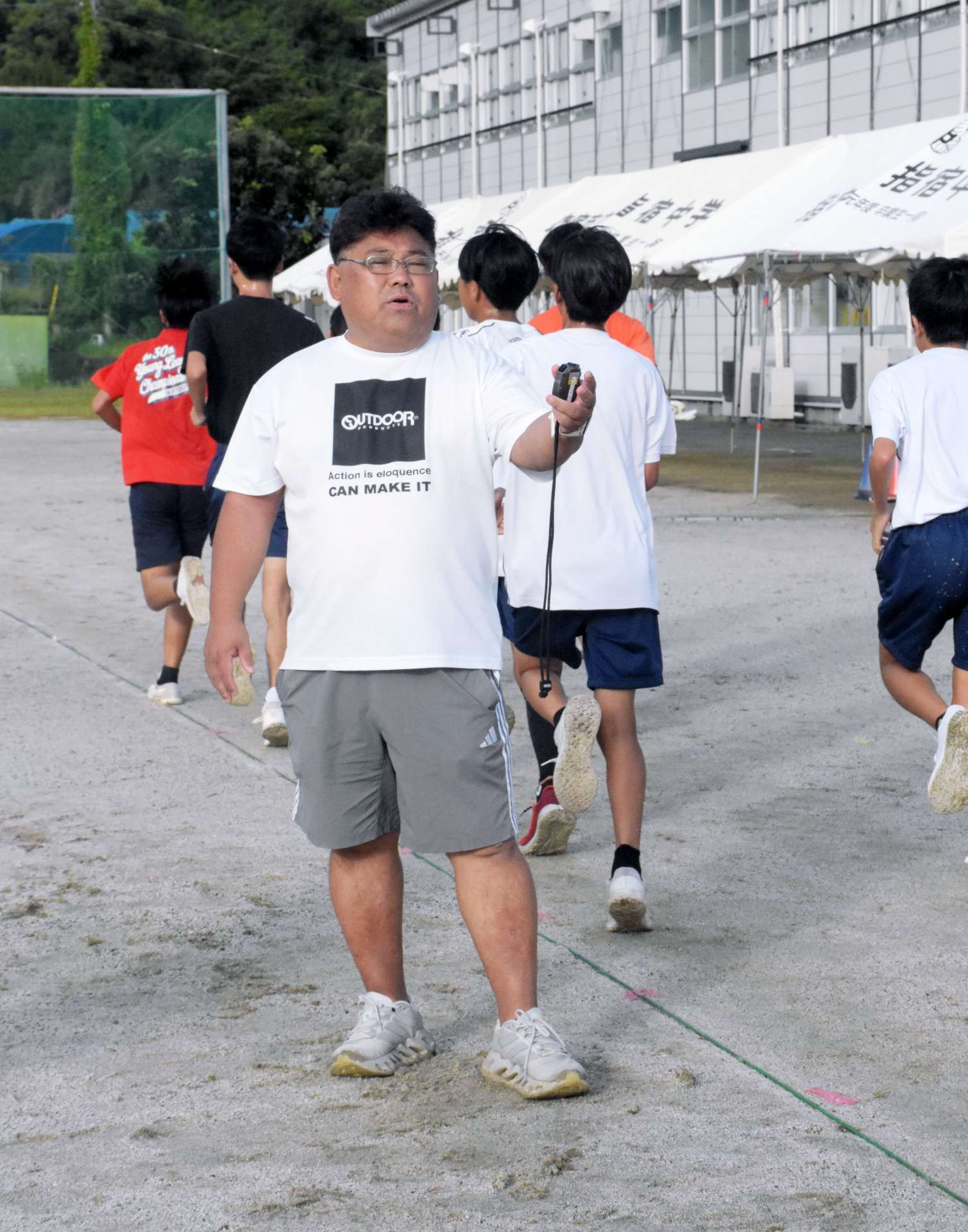 ランニングする生徒に声をかける新小田造さん＝指宿市の南指宿中学校