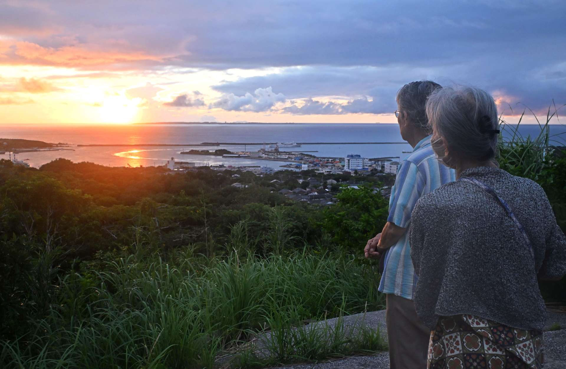 夕日を眺め平和を願う市民ら＝２３日午後６時すぎ、西之表市