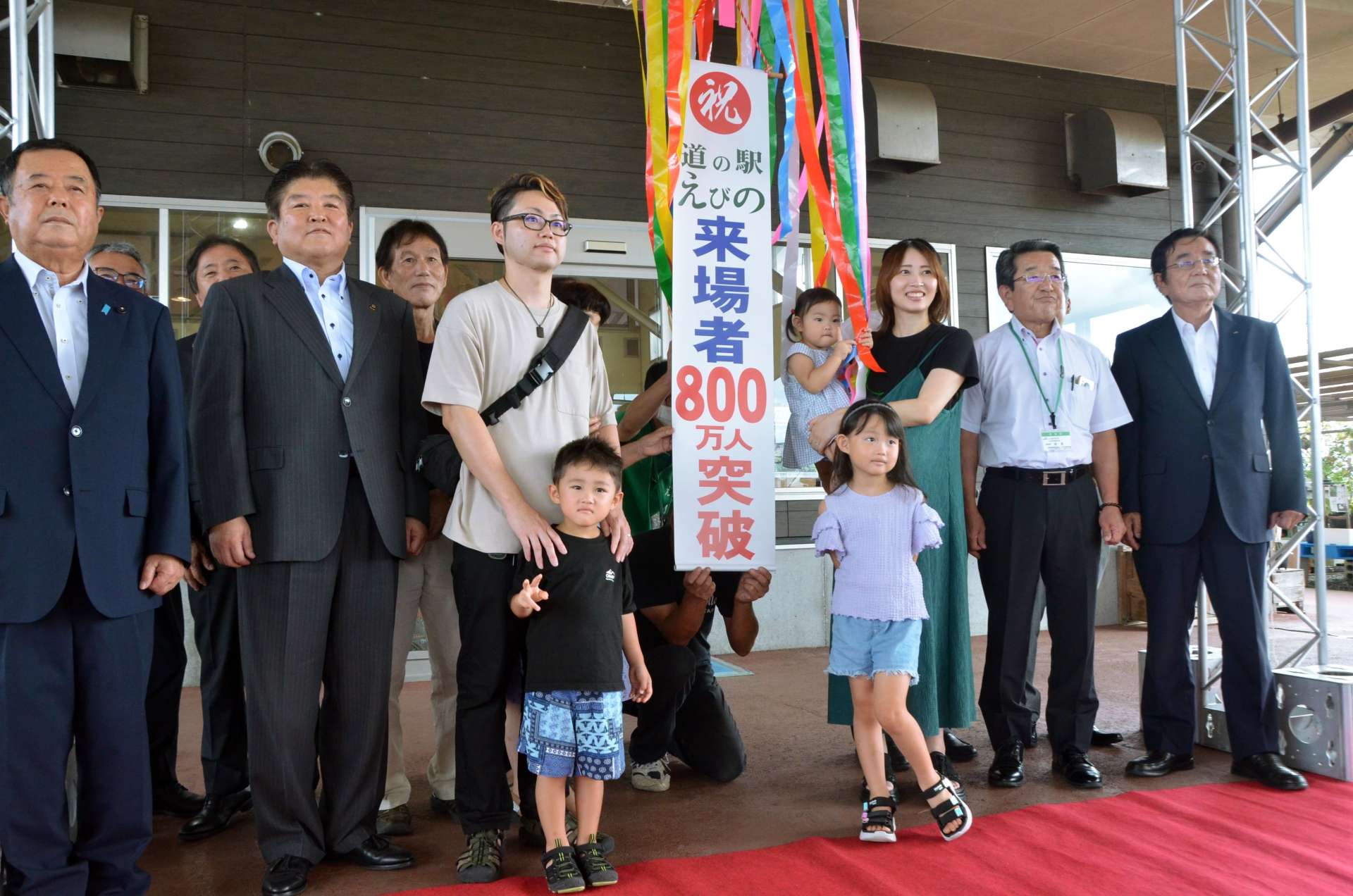 来場者８００万人突破を祝う野間裕人さん家族と関係者＝えびの市永山の道の駅えびの