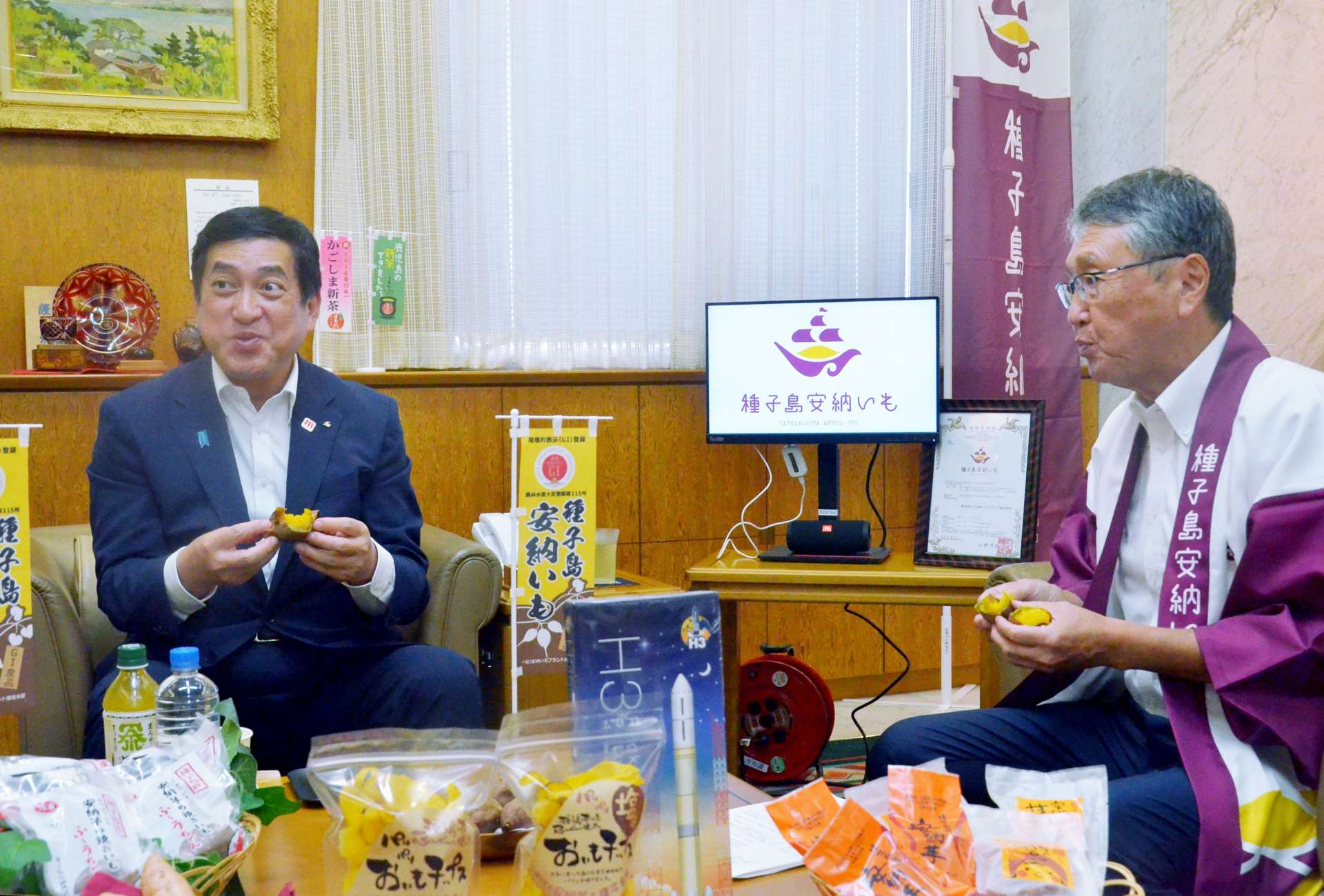 出荷が始まった「種子島安納いも」の焼き芋を食べる塩田康一知事（左）ら＝２４日、鹿児島県庁