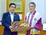 出荷が始まった「種子島安納いも」を塩田康一知事（左）に贈る「安納いもブランド推進本部」の八板俊輔会長＝２４日、鹿児島県庁
